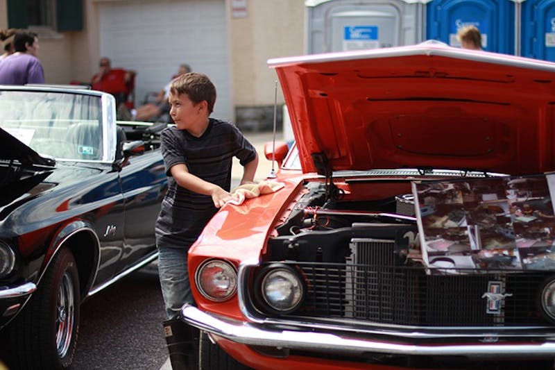 A young member of the Shippensburg community examines cars at the festival’s antique auto show.&nbsp;