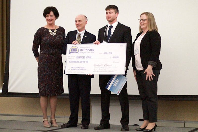 Logan Chernicky (second from right) wins first place and is awarded $10,000 for his business that allows construction managers to keep track of their projects.