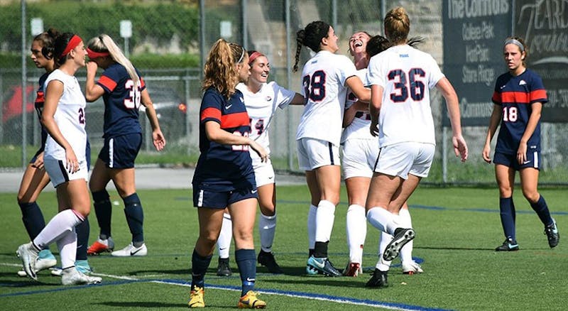 Other members of the soccer team crowd around forward Izzy Weigel after her 80th-minute game-winner. Weigel leads the team with four goals this season.