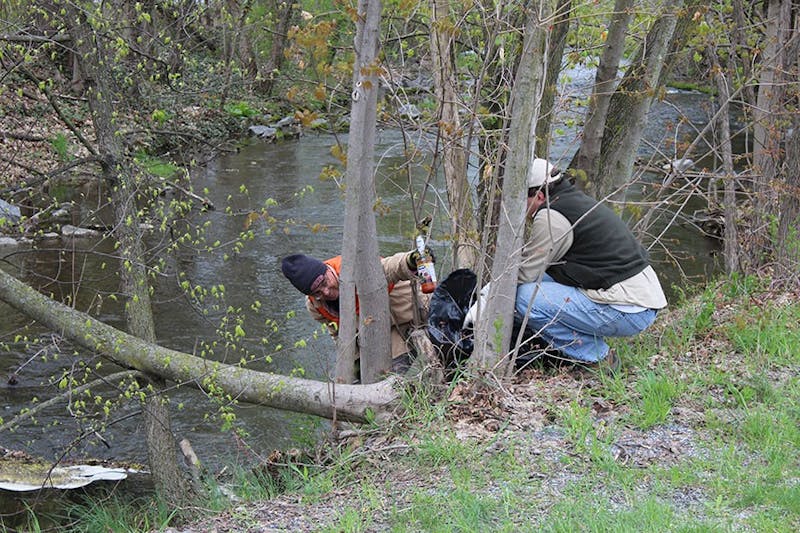 Blyden Potts (left) picks a bottle out of the Middle Spring stream during last year’s Stream Awareness Day.