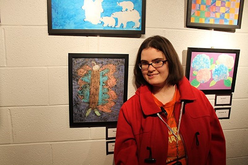 Melissa A. proudly displays her art work at SHAPE Gallery.