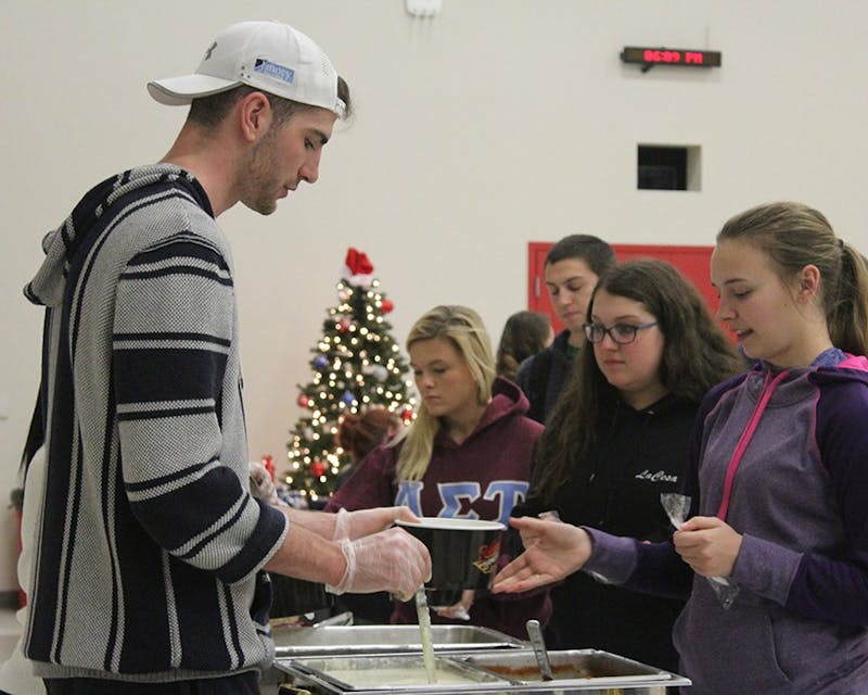 Student Senate Secretary Trent Bauer serves food to the students.