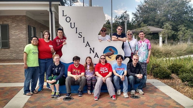 (top row left to right): John Cox, Stephanie Dougherty, Christopher Nguyen, Cathy Campbell, Brandon Wagner, Jan Bye and Austin Wisser. (Bottom row left to right): Theresa Schwarzwalder, Benjamin Uleau, Emily Wagner, Mandee Staub, Dietrich Grakauskas and Joseph Funk take a break during their travels and head to a Lousisiana rest stop, posing with a state sign.