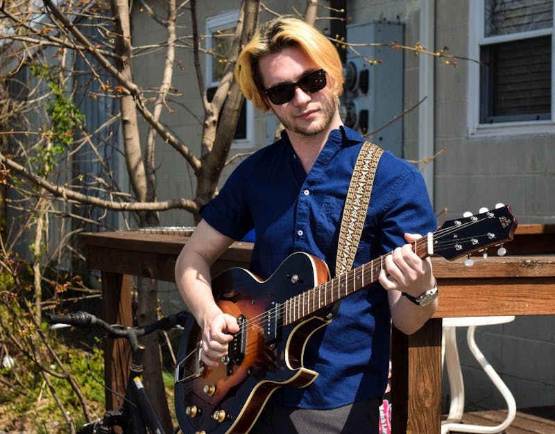 Tyler Michael Law strums his Loar Hollowbody outside his apartment near Wibs.