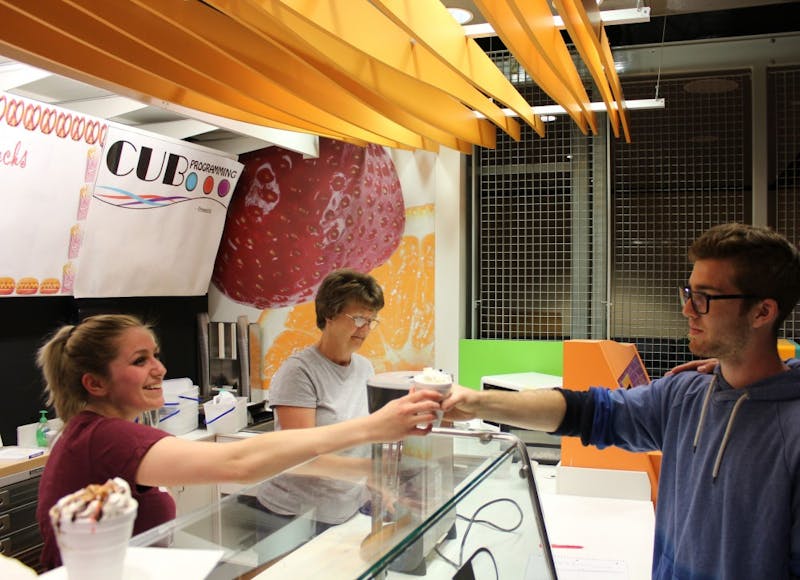 Jessica Gill hands Andrew Thiel a milkshake to serve to a student at Afterhours for its first event at the CUB