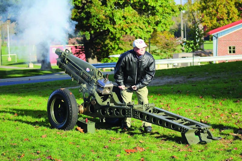 SU President Jody Harpster signals the start of the race with an M116 Howitzer.