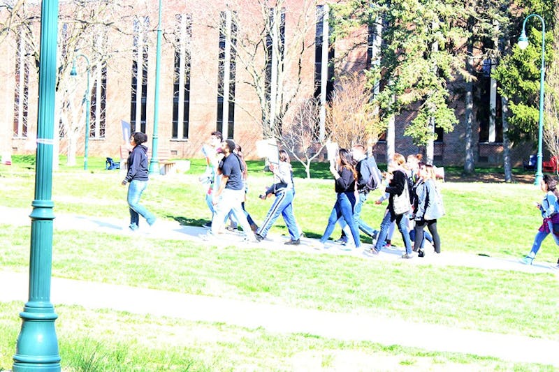 Carrying signs and banners, more than a dozen students march in the quad. The march is meant to draw attention to Arizona’s ID laws, and to stand in spirit with the people it targets.