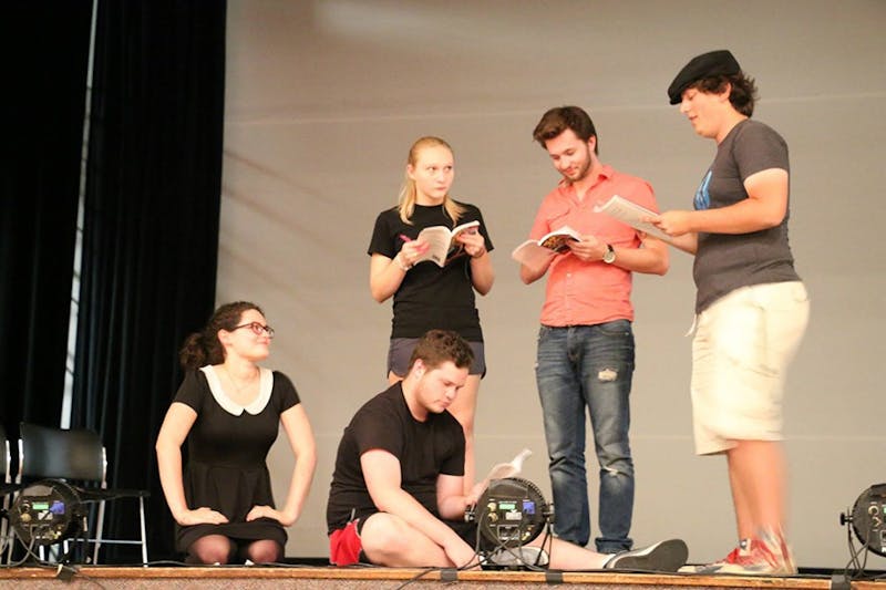 The cast of “The 39 Steps” talks with director Nic Ecker on stage about the last scene during a rehearsal in early September.