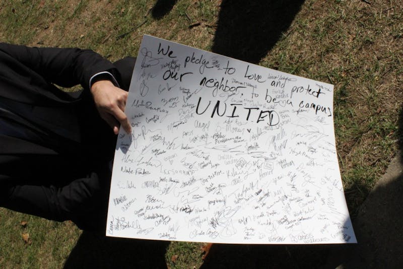 Students sign a banner pledging to protect their fellow students on campus.