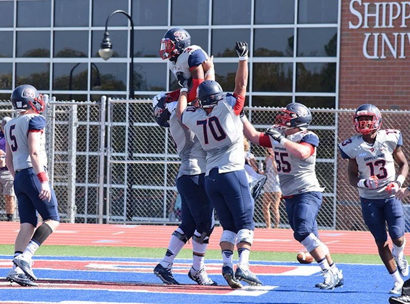 The Shippensburg University offensive line celebrates with Charles Headen III (No. 3), after he scored a touchdown on the first drive of the game Saturday.