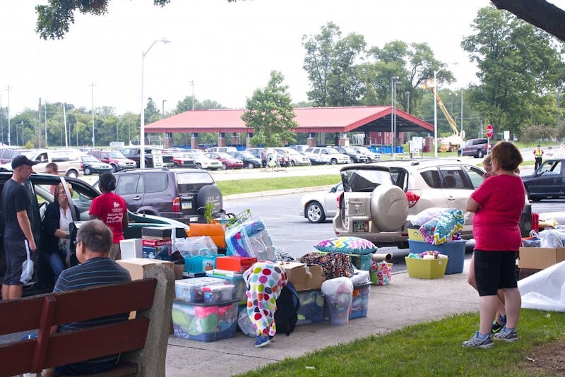 	A new student&#8217;s car has been unloaded on to the sidewalk to wait for a cart to start transporting things to her room.