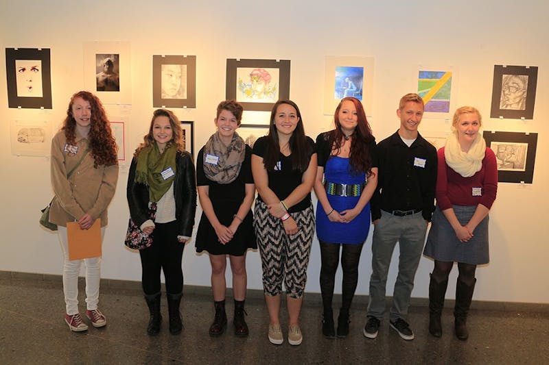 The winners of the art gallery contest pose with some of the works created by fellow students.