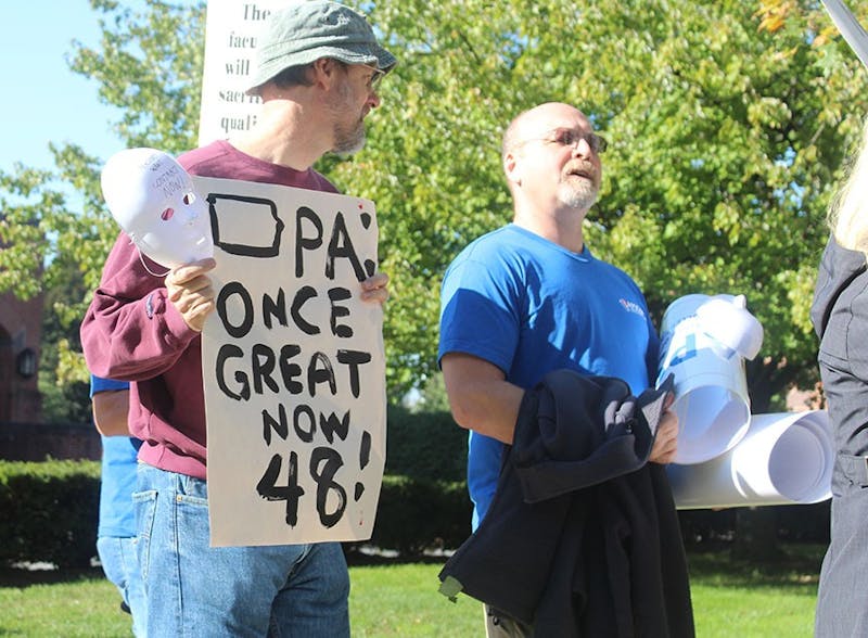 A protestor walks the picket line at Friday’s rally in Harrisburg.