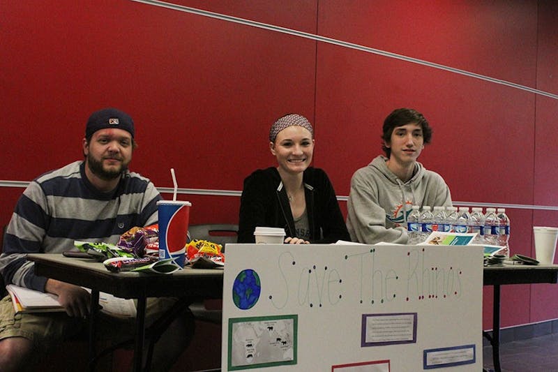 (Left to right) SU students Andrew Dunn, Bri Hopkins and Cameron Kline set up a "Save the Rhinos" information booth on Earth Day, to educate people about the plight of rhinos. 