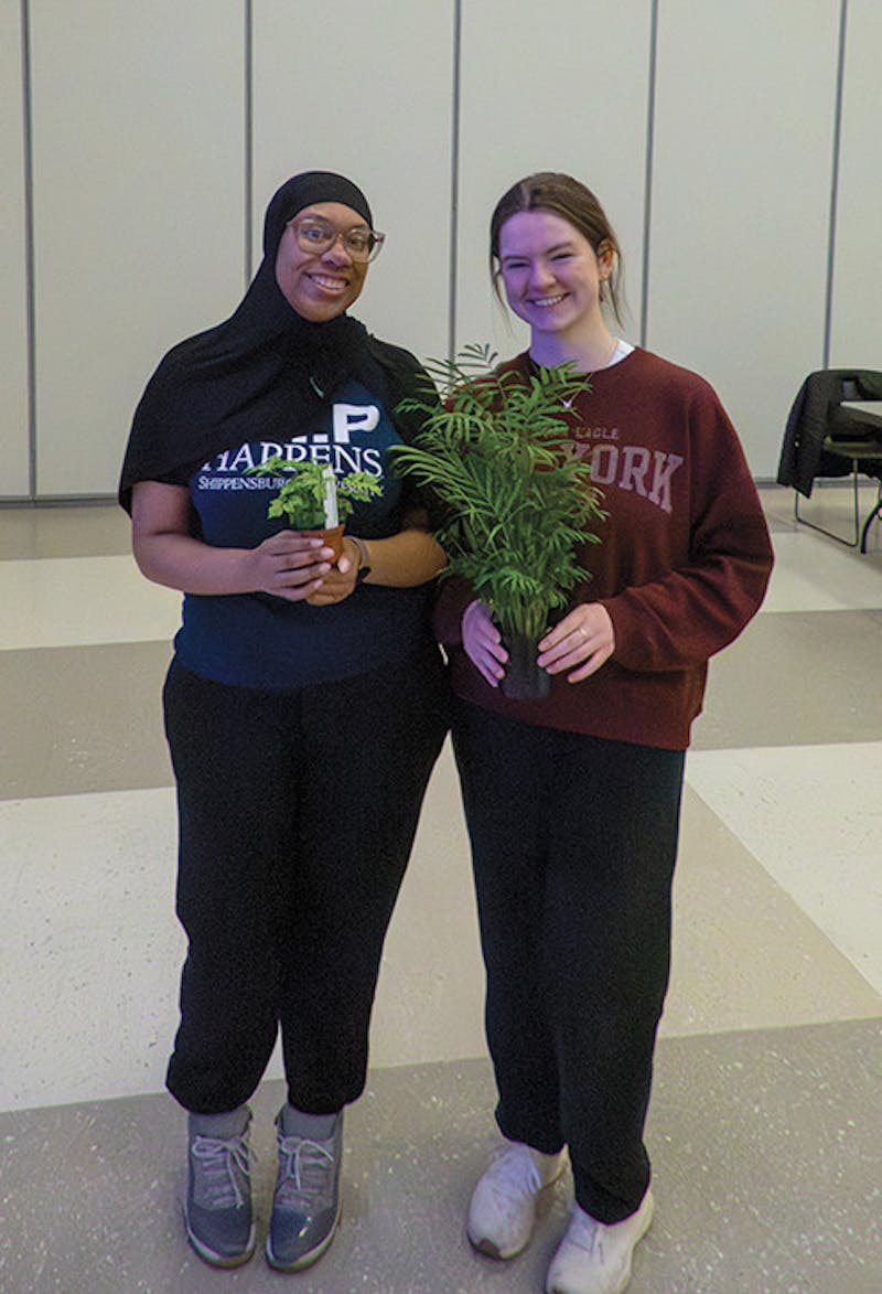 Two winners of plant bingo showing off their prizes.&nbsp;