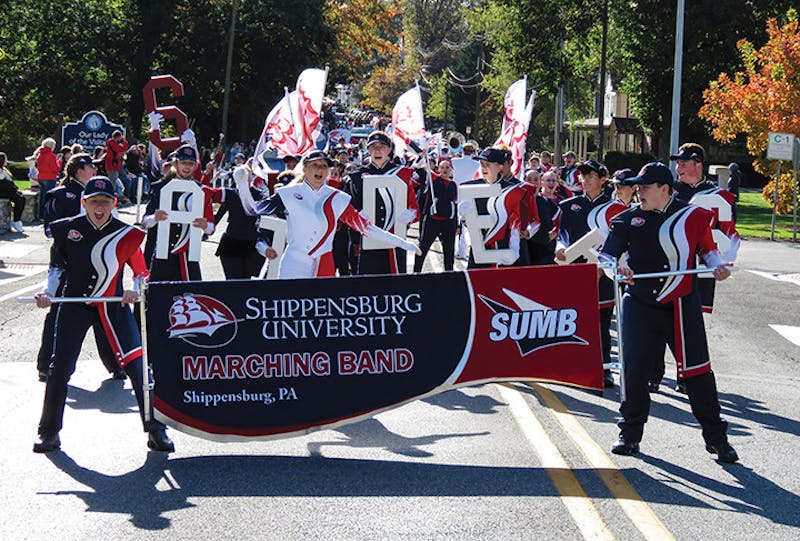 The Shippensburg University Marching Band makes its way down North Prince Street, drumming up cheers of support for the Raiders football team.