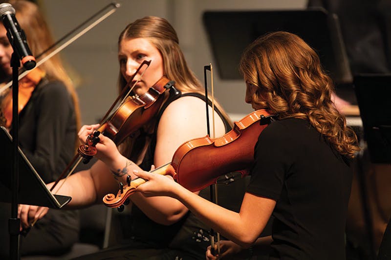 From left, Alex Clippinger and Jayden Pohlman playing the second violin in the SU Community Orchestra.