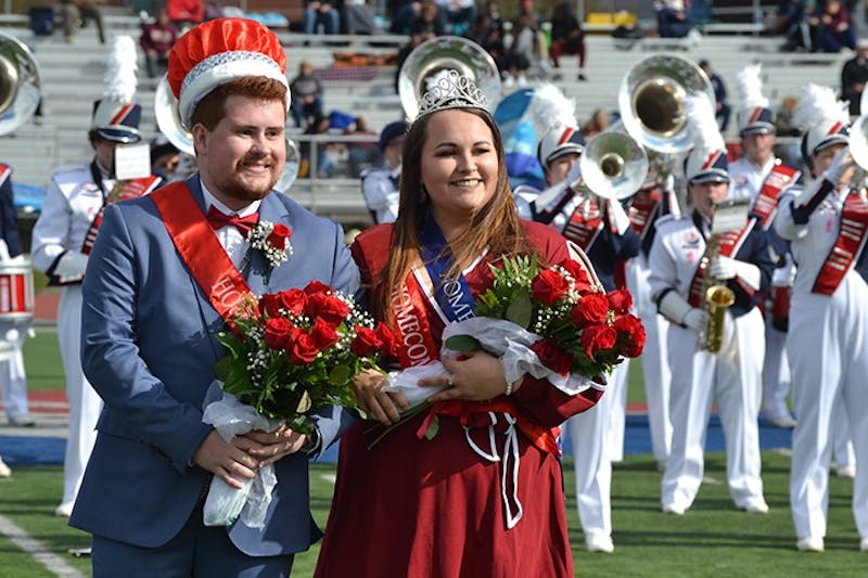 Tyler Rock and Bernie Schneider pose for photos after being announced homecoming king and queen during Saturday’s football game. The homecoming court raised money for Hound Packs to benefit local students.