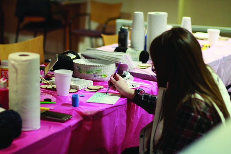 A Shippensburg University student paints on canvas during the SU Women’s Center event. 