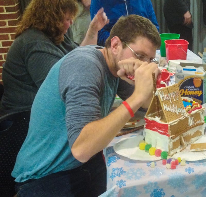 Student Senate treasurer Justin Schneider, of Team Secret Santa, pipes frosting onto his team's gingerbread house.