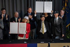 Purdue and IU Presidents hold up Agreement Papers