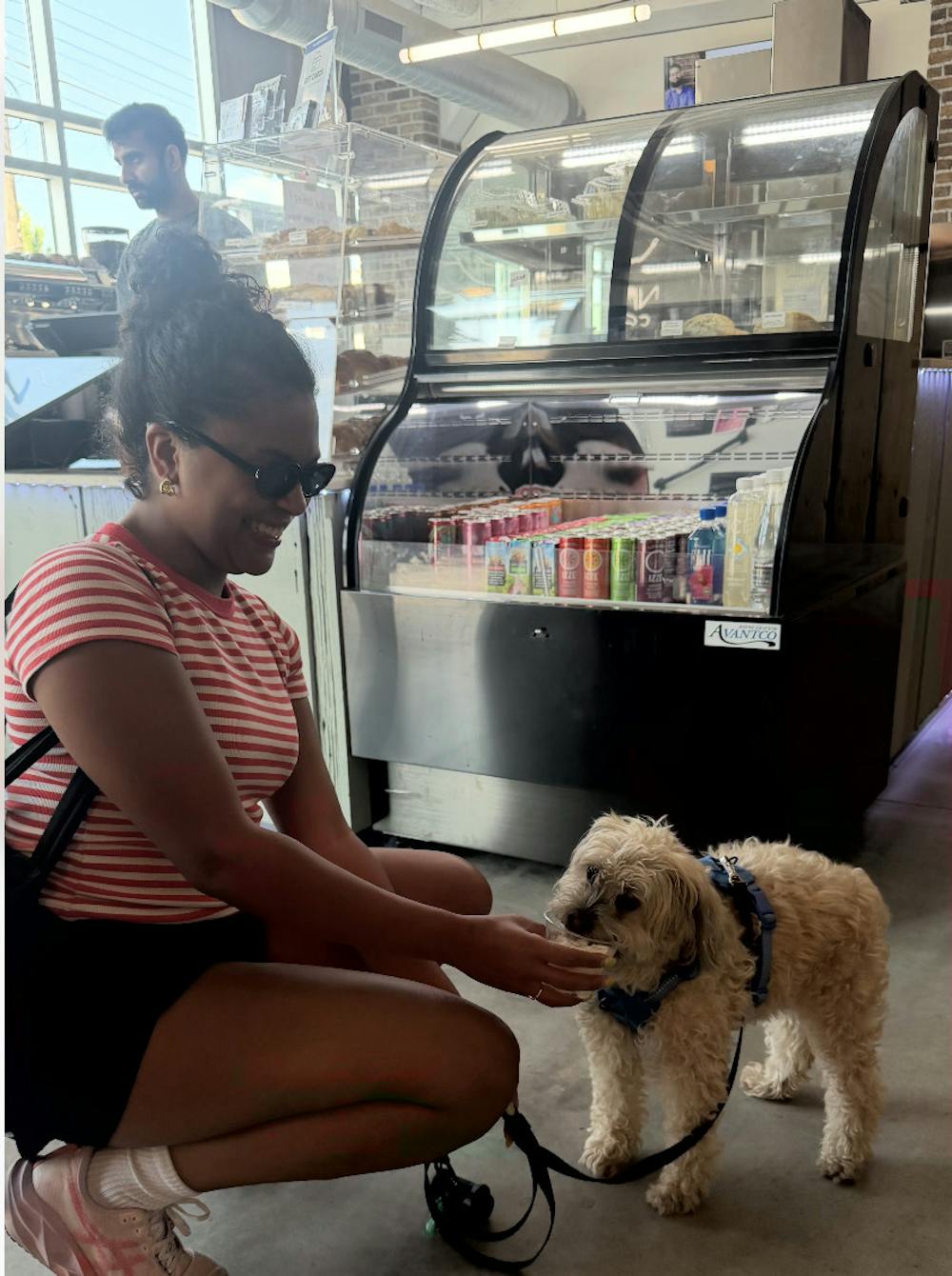 Niyyah Coffee customer Bianca Matchain feeds her dog a pup cup inside the downtown Indianapolis cafe. Matchain said workers give her dog a pup cup each time they visit. 
