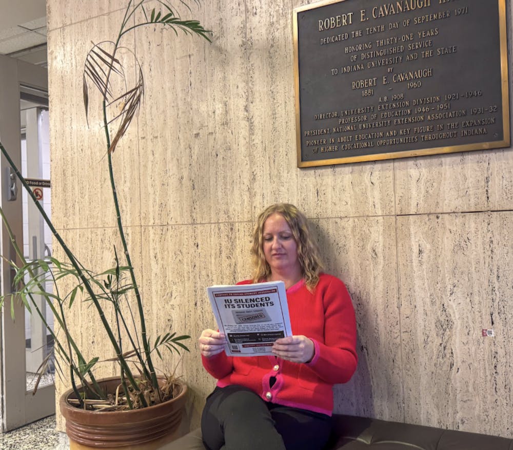 Maggie Hutton, a J.D. candidate at IU McKinney School of Law, reads a flyer about the upcoming protest in support of the Indiana Daily Student while sitting inside Cavanaugh Hall on Monday. Hutton organized the demonstration to oppose IU’s decision to end the student newspaper’s print operations and dismiss its media director.