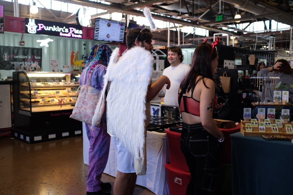 <p>Big Gay Halloween attendees browse the market in costume.</p>