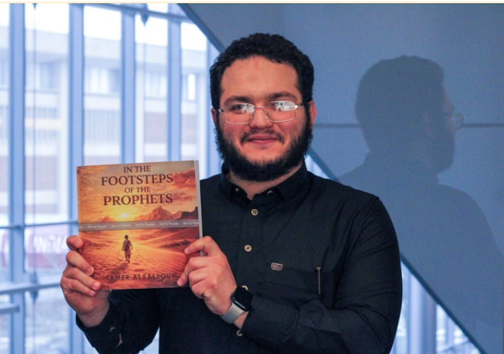Tamer Abdul Halim Alsalloum, author of "In the Footsteps of the Prophets," holds a copy of his book. Illustrations were done with Generative AI from Canva. 
