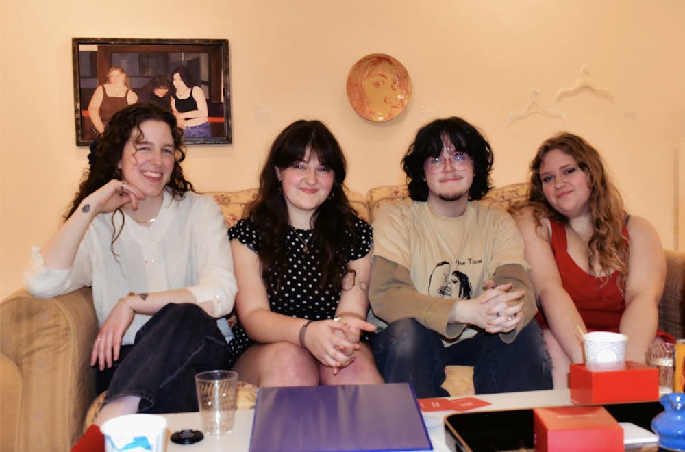The creators of “At the Tone,” Cecily Walsman (left), Ella Fupel (middle left), Jack Melton (middle right),  Sophie Sturgeon (right) sitting in the exhibit. (Photo courtesy of Jack Melton)