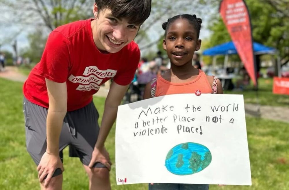 <p> Attendees at 2024 Peace Walk pose with sign that says “Make the world a better place not a violent place.” Photo courtesy of @<a href="https://www.instagram.com/studentsdemand_herron/" target="_blank">studentsdemand_herron</a>.</p><p></p>