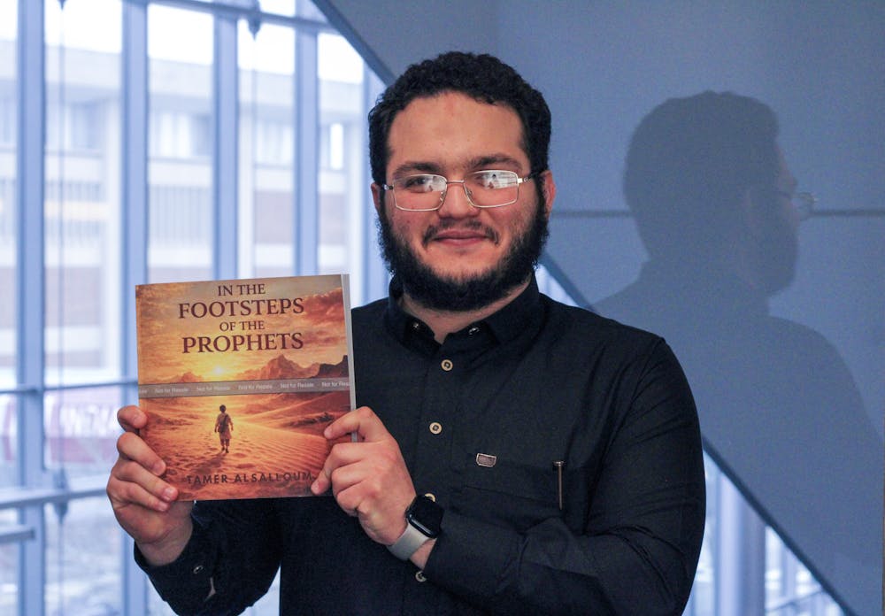 Tamer Abdul Halim Alsalloum, author of "In the Footsteps of the Prophets," holds a copy of his book. Illustrations were done with Generative AI from Canva.