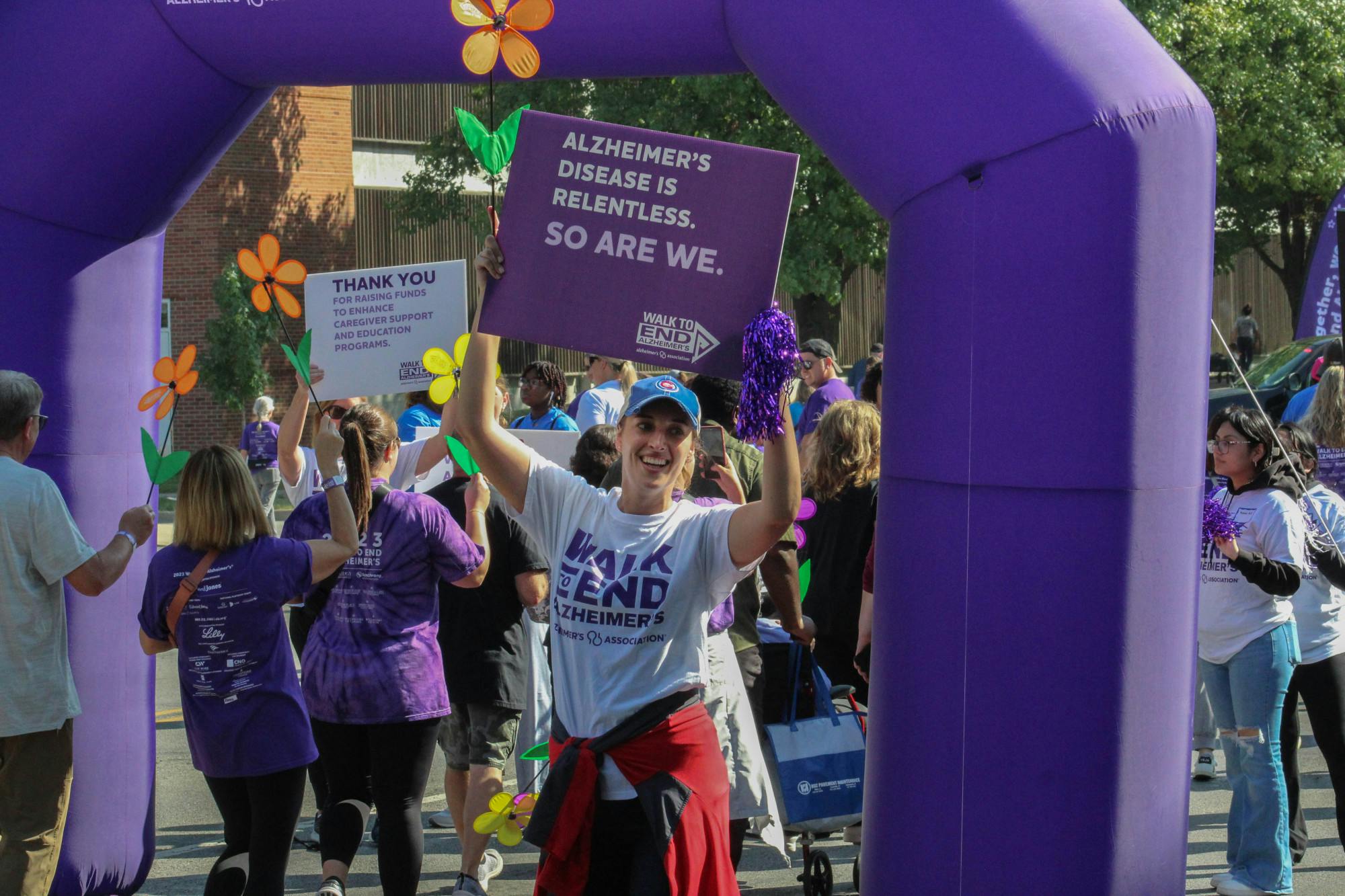 A volunteer cheers walkers on as they cross the finish line