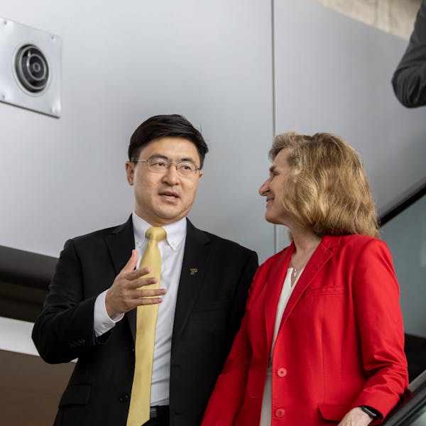 IU President Pamela Whitten and Purdue President Mung Chiang descend escalator together before ceremony