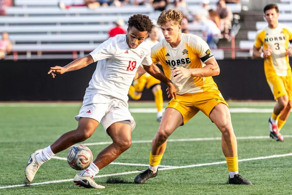 Forward No. 19 Micah Eldridge dribbles the ball while a Northern Kentucky player defends him. (Photo courtesy of Damian Davis/IU Indy Athletics Gallery)