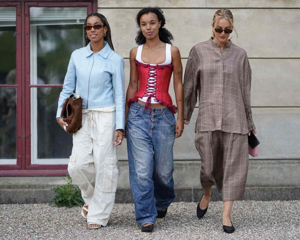 Three guests outside Munthe during Copenhagen Fashion Week in August 2025. (Photo courtesy of Edward Berthelot/Getty Images)

