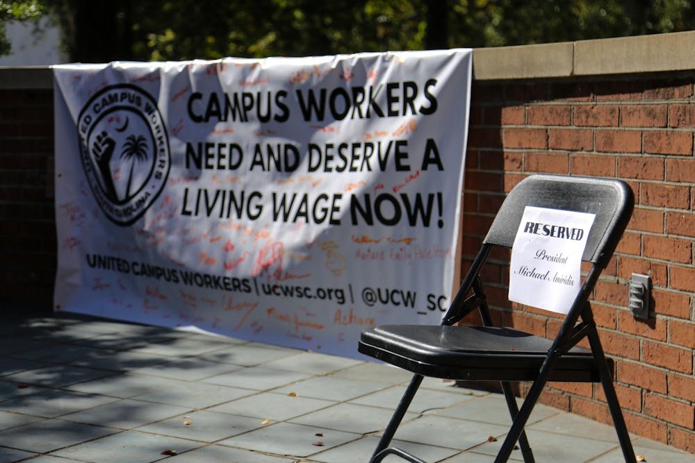 <p>FILE — A folding chair reserved for University of South Carolina President Michael Amiridis sits empty on the stage of the Russell House patio during a USC worker speak-out event on Oct. 26, 2023. The event was hosted by the United Campus Workers union at USC.</p>