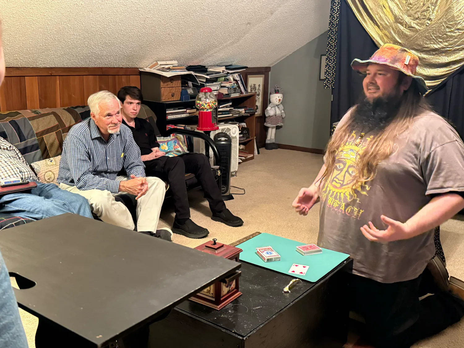 Christian Tillison performs a card trick as Tony Metze and Tony Campbell watch on. All three are members of International Brotherhood of Magicians Ring 105, a local club.
