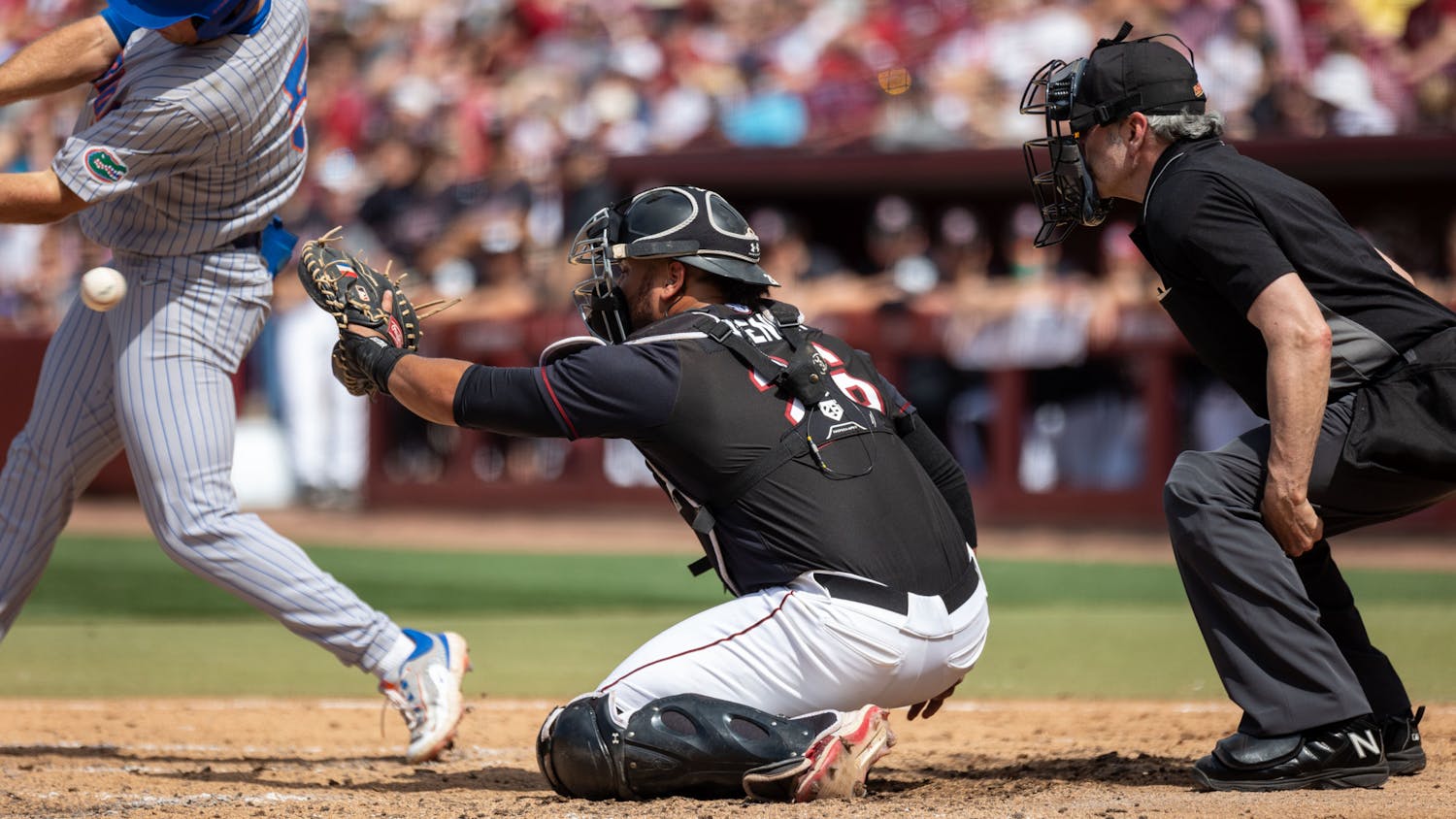 Senior catcher Jonathan French reaches for the pitch as it passes by Florida junior infielder Colby Halter during the finale against the Gators at Founders Park on April 22, 2023. At the plate, French was 1-2 with a run scored and two walks.
