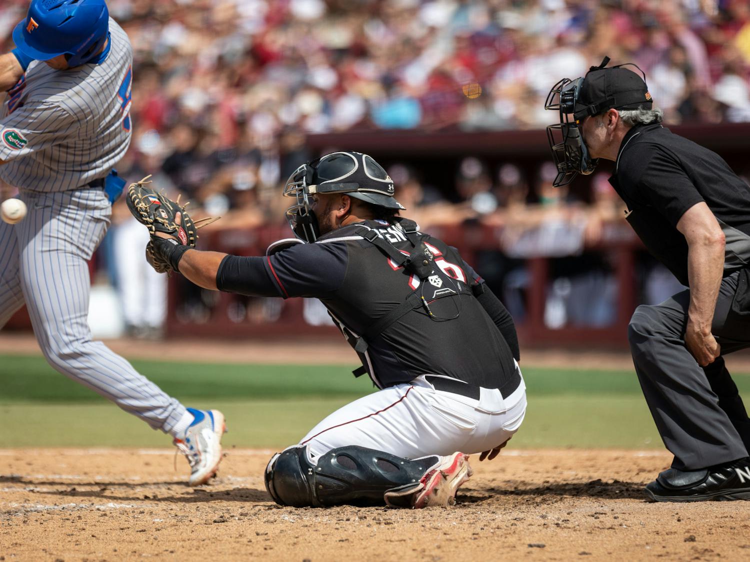 Senior catcher Jonathan French reaches for the pitch as it passes by Florida junior infielder Colby Halter during the finale against the Gators at Founders Park on April 22, 2023. At the plate, French was 1-2 with a run scored and two walks.