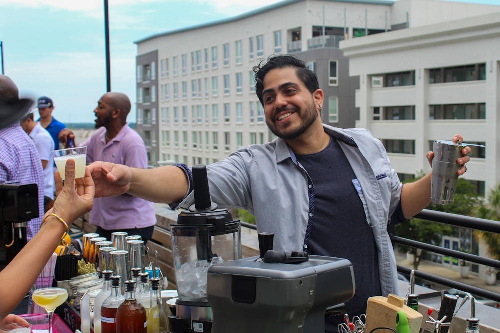 <p>Boku bartender and Capital City Cocktail competitor Raynaldy Rodriguez hands a drink sample to a patron on June 9, 2024. The event, hosted by Bubblee Mixologist, highlights the Midlands' industry creatives and their unique craftsmanship and innovation.</p>