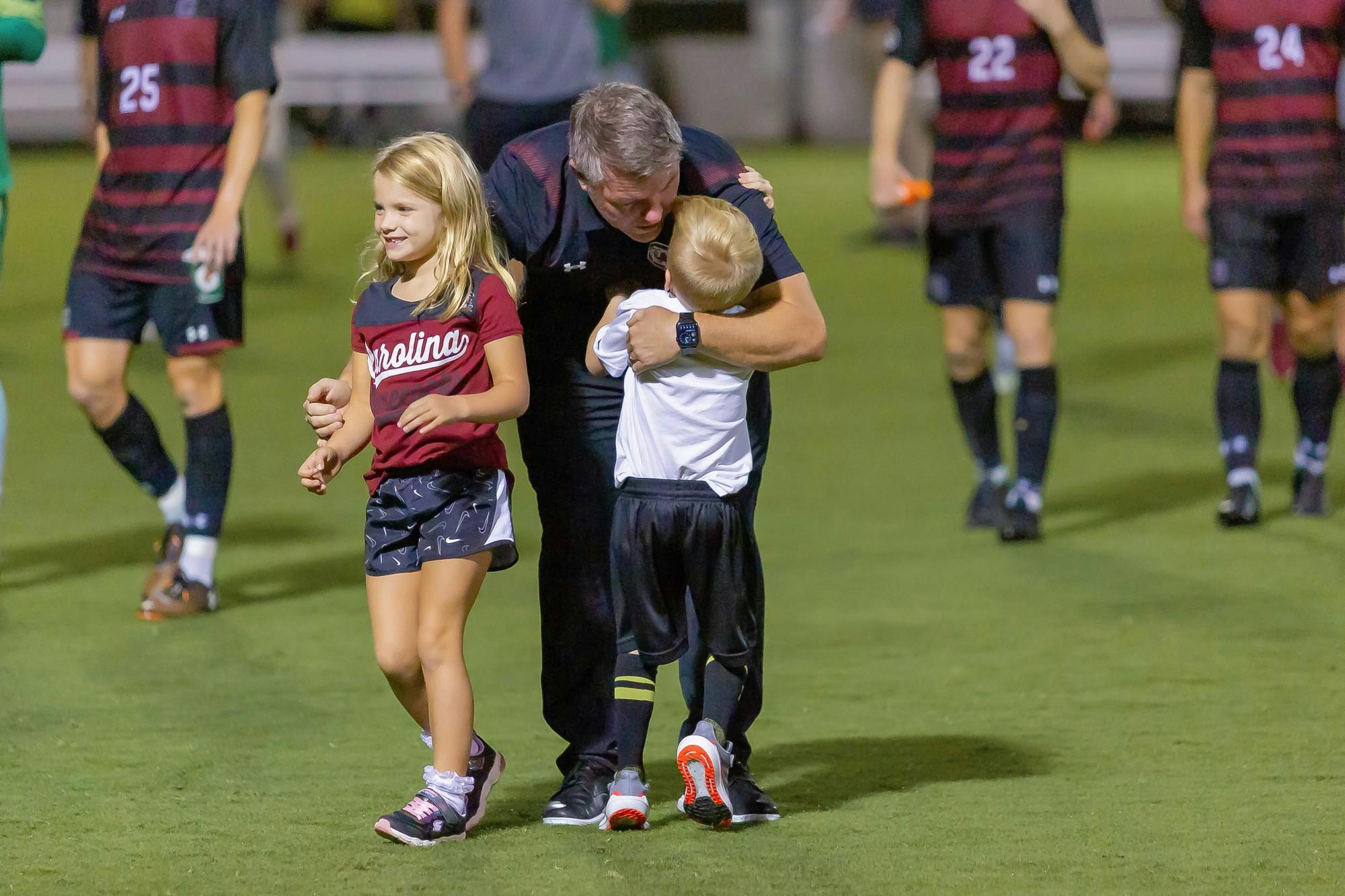 South Carolina men's soccer coach Tony Annan meets his children on the field following a victory over Gardner-Webb on Sept. 28, 2021. 