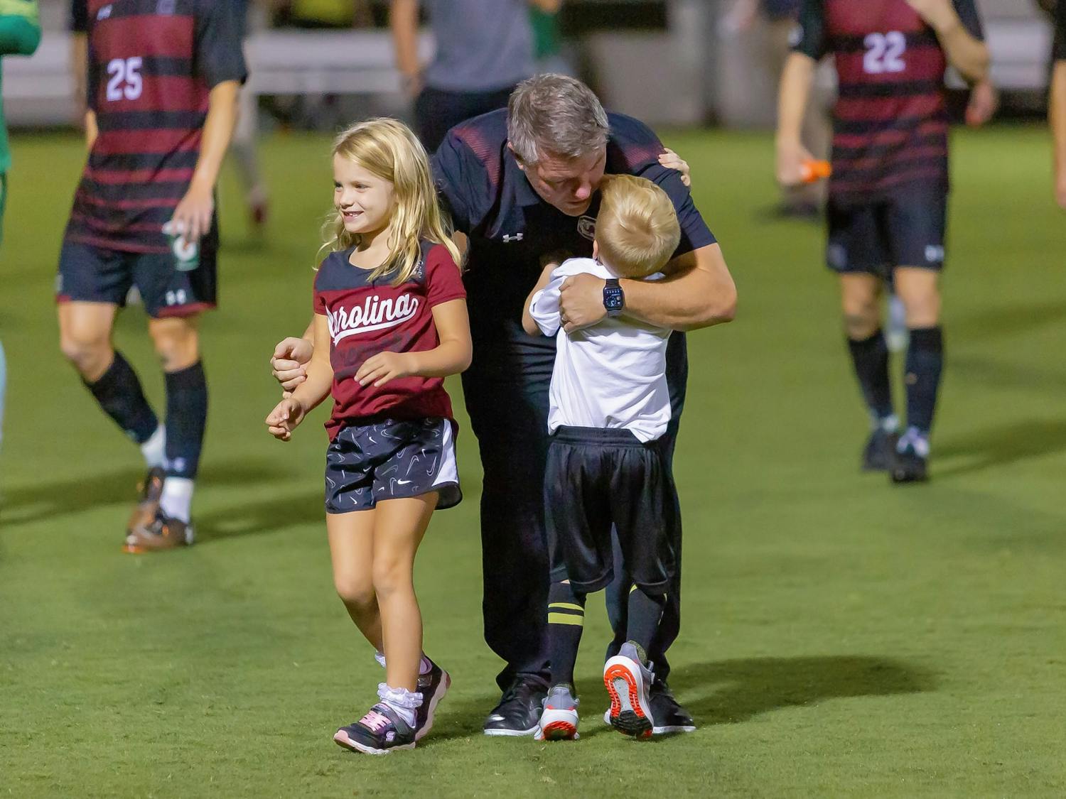 South Carolina men's soccer coach Tony Annan meets his children on the field following a victory over Gardner-Webb on Sept. 28, 2021. 