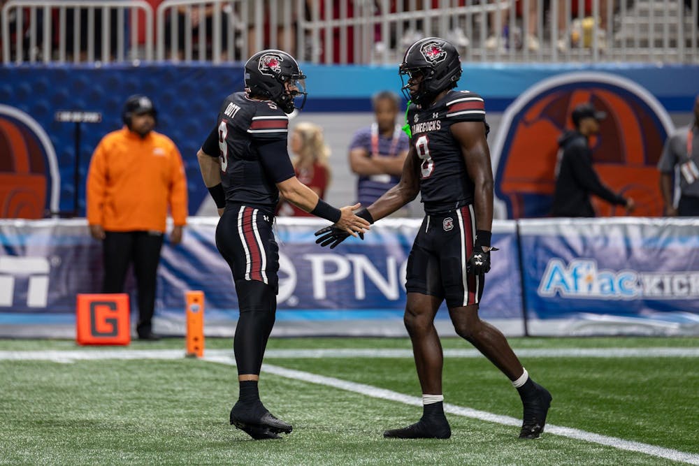 <p>FILE — Graduate student athlete Luke Doty (left) and junior wide receiver Nyck Harbor (right) high-five on the field during a game against Virginia Tech on Aug. 31, 2025, at Mercedes-Benz Stadium in Atlanta, Georgia. Harbor contributed 99 receiving yards and one touchdown to the Gamecocks' 24-11 win over the Hokies to start its season.</p>