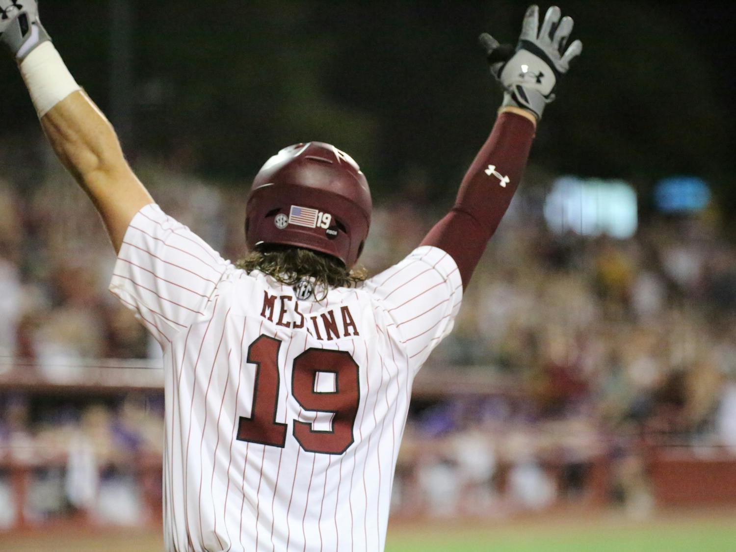 Sophomore catcher Cole Messina throws his hands in the air after freshman outfielder Ethan Petry hits a grand slam for the Gamecocks, expanding its lead against the Tigers. No. 6 South Carolina won the first game of the two-game series 13-5 against No. 1 LSU on April 6, 2023, at Founders Park.&nbsp;