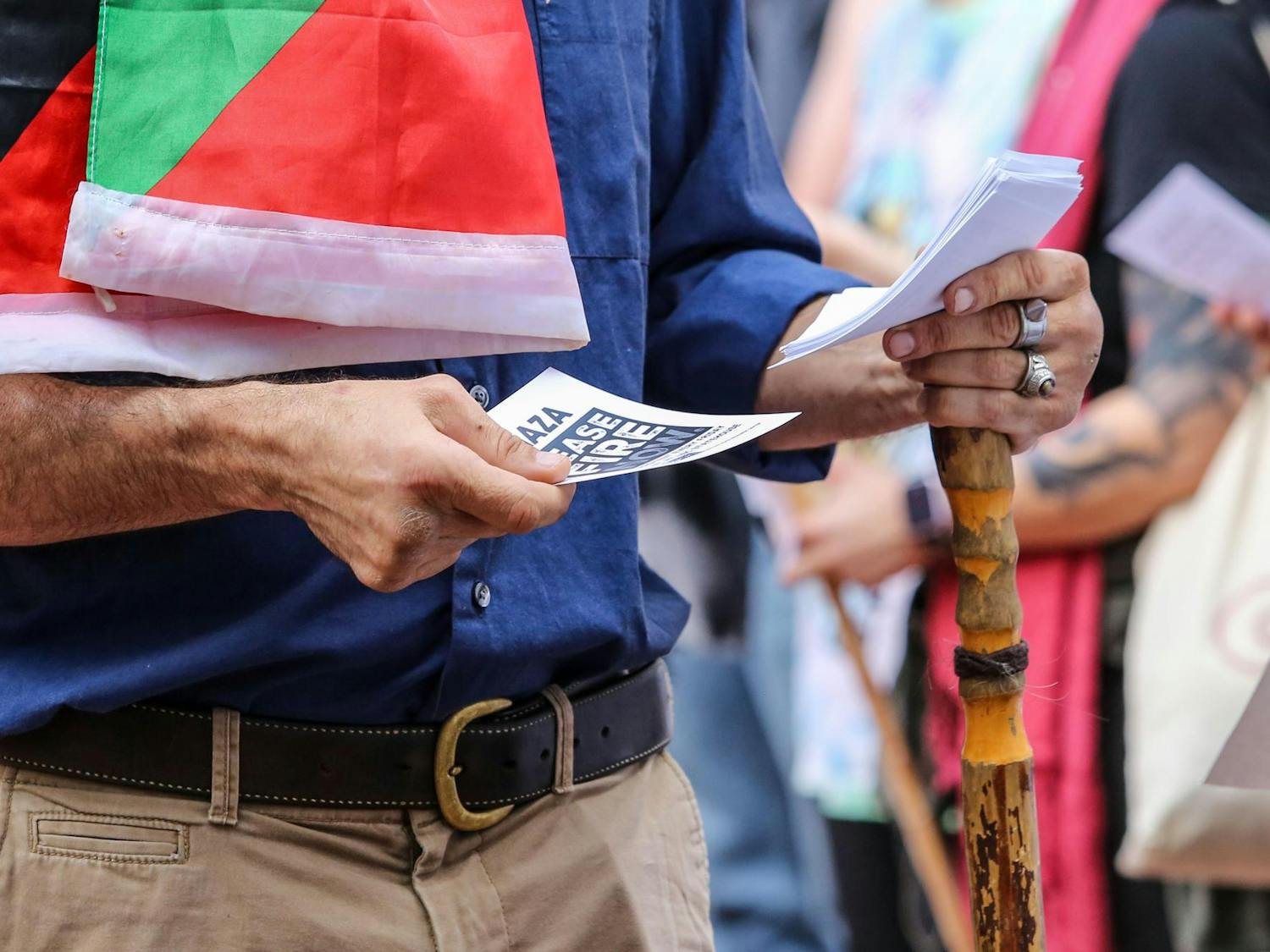 An attendee hands out leaflets during a walkout for Palestine on the Russell House Patio on Nov. 9, 2023. The leaflets contained information from the Carolina Peace Resource Center on pro-Palestinian protests held every Friday at the Statehouse.