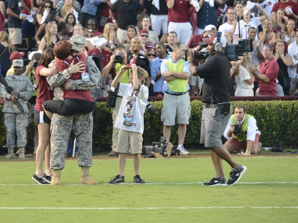 Sgt. 1st Class Scott Faile surprises his family as he ends his tour of duty in South Korea at Williams-Brice Stadium Saturday.