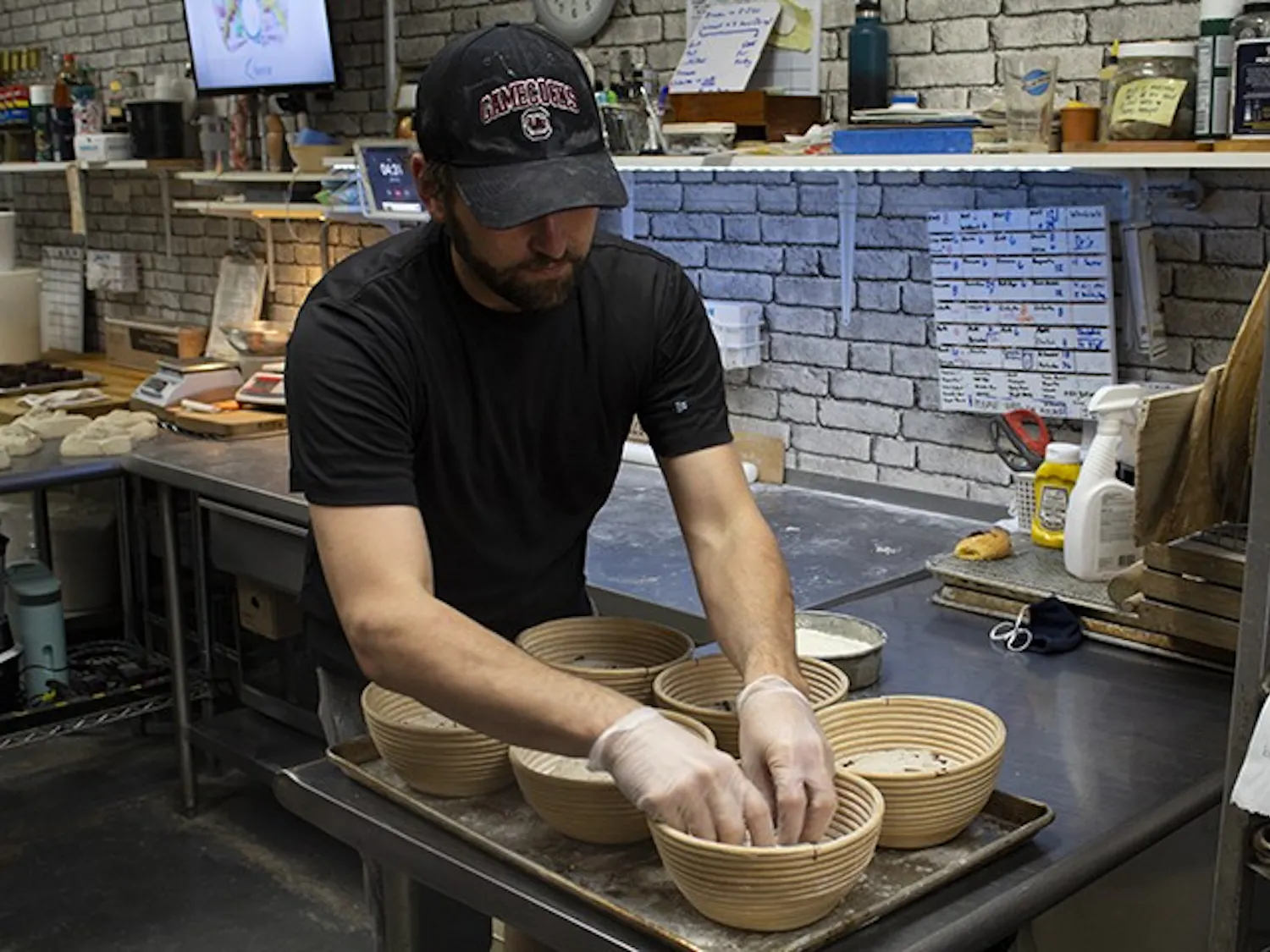 Owner of Crust Bakehouse Zackery Gates works in the kitchen to prep inventory. 