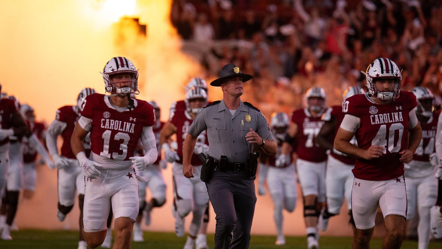 Members of the South Carolina football team run out of the tunnel alongside a member of the South Carolina Highway Patrol prior to South Carolina's game against Akron on Sept. 21, 2024 at Williams-Brice Stadium.