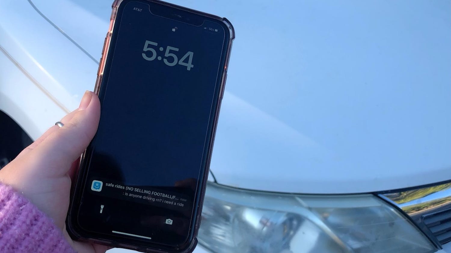 A phone with a message from the "safe rides" GroupMe. The group chat provides predominantly USC female students with transportation from their peers.